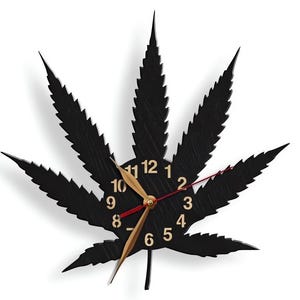 Könnte beinhalten: Schwarze Wanduhr in Form eines Marihuana-Blattes mit goldenen Zahlen und Zeigern. Das Zifferblatt der Uhr hat die Zahlen 1 bis 12.