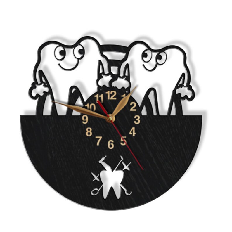 May include: A black and white wooden clock with a design of two cartoon teeth holding a toothbrush. The clock face has gold numbers and hands. The clock is shaped like a half circle and has a black background. The clock also has a small silver tooth with dental tools crossed behind it.