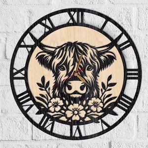 May include: A round wooden wall clock featuring a black silhouette of a Highland cow's face, surrounded by a black Roman numeral clock face. The clock hands are gold with red tips, and floral accents are at the bottom.