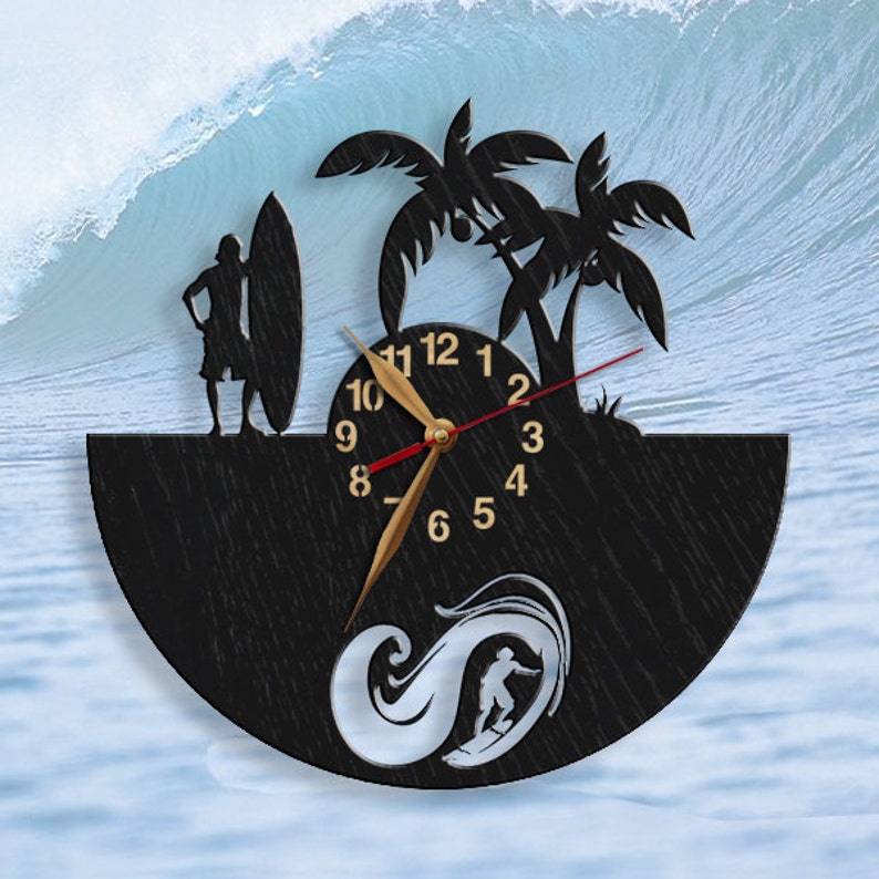 Pu&ograve; includere: Orologio da parete nero a tema surf. L'orologio presenta una silhouette di un surfista, palme e un surfista con una tavola da surf. Le lancette dell'orologio sono dorate e i numeri sono in un font classico. Lo sfondo &egrave; un'onda blu.