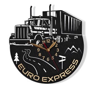 May include: Black wooden clock featuring a white silhouette of a semi-truck and trailer. The clock face has gold numbers and hands. The clock is surrounded by a black and white road, a pine tree, and mountains. The words "EURO EXPRESS" are written in gold around the bottom of the clock.