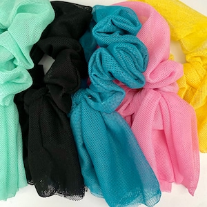 May include: Five colourful hair scrunchies made of mesh fabric. The scrunchies are in the colours teal, pink, black, light green, and yellow.