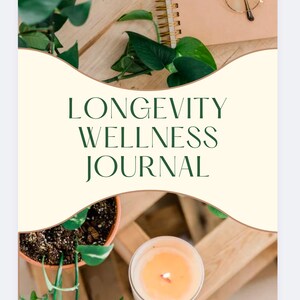Op de afbeelding: Een wit dagboek met de tekst "LONGEVITY WELLNESS JOURNAL" in groene letters op een crèmekleurige achtergrond. Het dagboek is omringd door groene planten en een brandende kaars.
