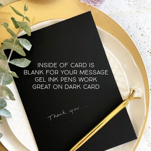 Pode incluir: Um cart&atilde;o preto com texto branco que diz "INSIDE OF CARD IS BLANK FOR YOUR MESSAGE GEL INK PENS WORK GREAT ON DARK CARD" e "Thank you..." escrito com tinta branca. Uma caneta dourada com uma parte superior em forma de diamante est&aacute; no cart&atilde;o.