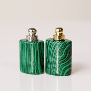 May include: Two small, square bottles with green malachite stone bodies and silver and gold metal tops.