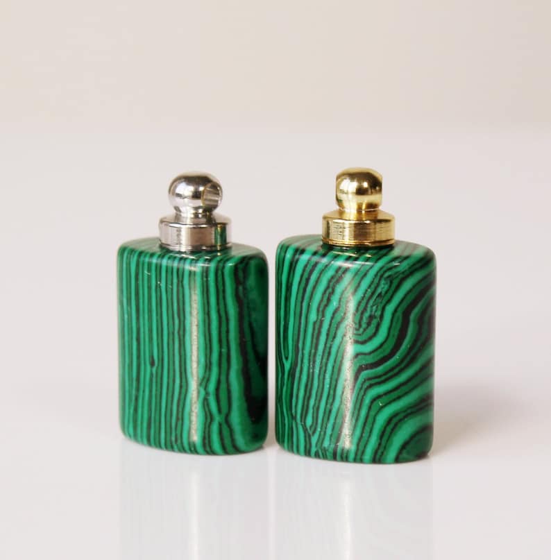 May include: Two small, square bottles with green malachite stone bodies and silver and gold metal tops.