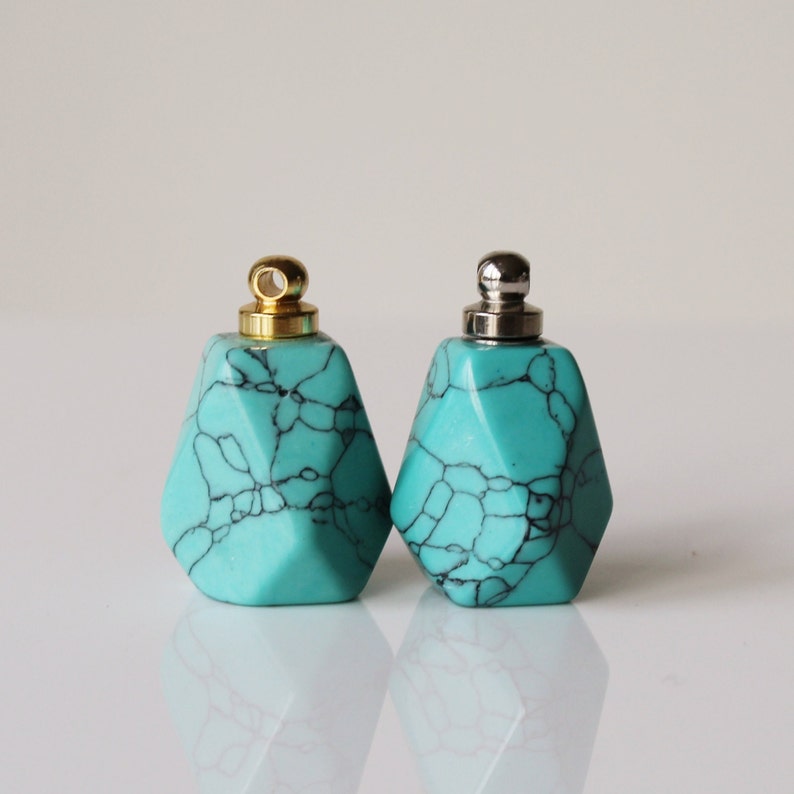 May include: Two turquoise blue geometric bottle stoppers with gold and silver tops.