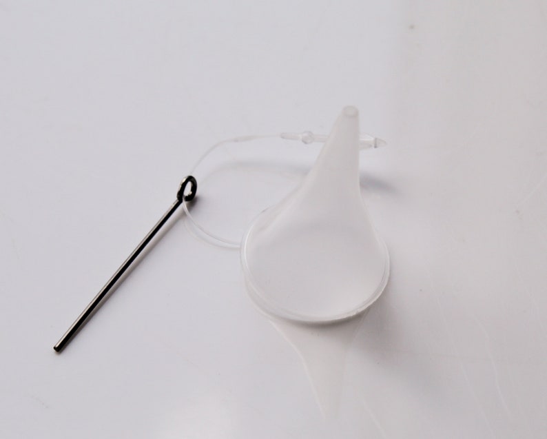 May include: A clear plastic funnel with a thin, flexible spout and a small loop at the top. A thin metal wire with a loop at one end is attached to the funnel.