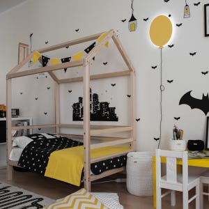 Natural solid wood house bed frame with removable rails set up in a modern kids bedroom with yellow decor.
