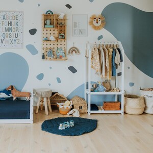Lower storage shelves on kids clothing rack for neat shoe and basket placement