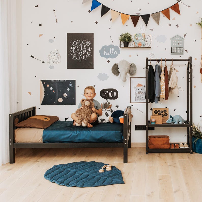 Dark wooden dress-up rail placed at kid height for hassle-free morning routines