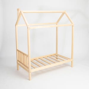 Studio product photo of the unpainted natural pine house bed frame on legs highlighting smooth sanded joints and base slats.