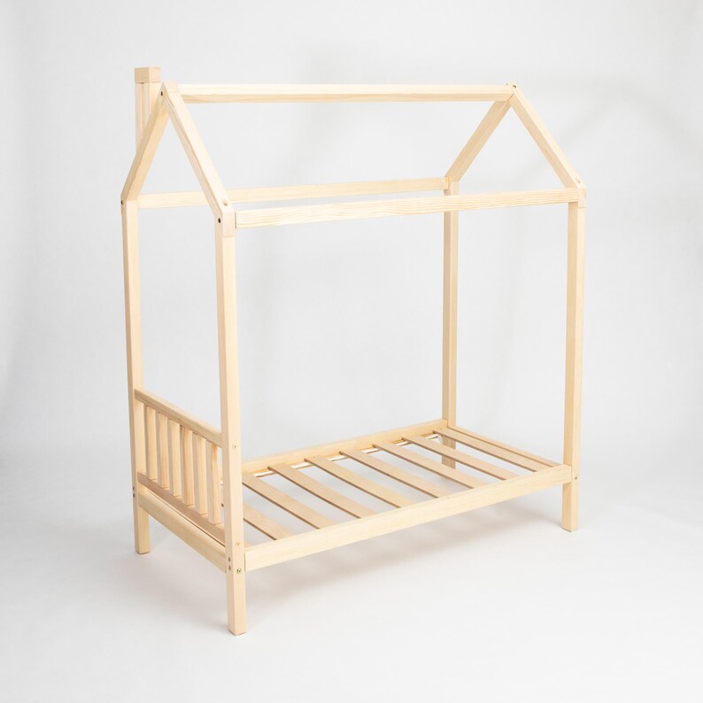 Studio product photo of the unpainted natural pine house bed frame on legs highlighting smooth sanded joints and base slats.