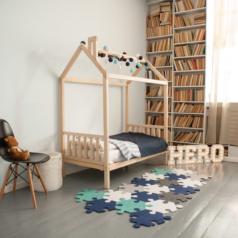 Natural solid wood platform bed frame with removable headboard and footboard in a decorated reading nook.