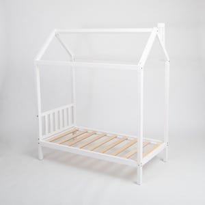 Front angle view of the white painted house bed frame with sturdy legs and supportive slatted wooden base on a white studio background.