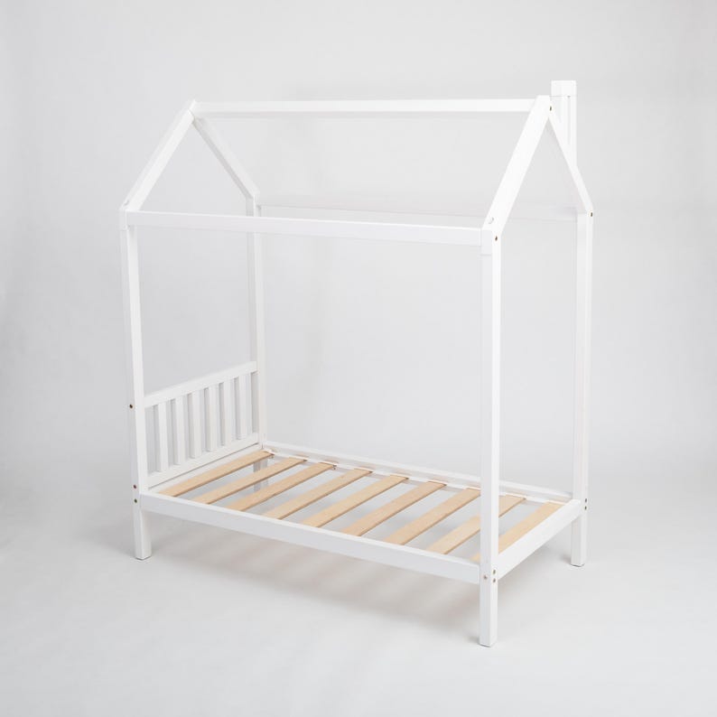 Front angle view of the white painted house bed frame with sturdy legs and supportive slatted wooden base on a white studio background.