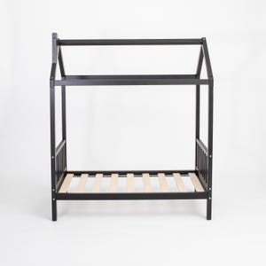 Black solid wood platform house bed frame with birch plywood mattress support slats on a studio backdrop.