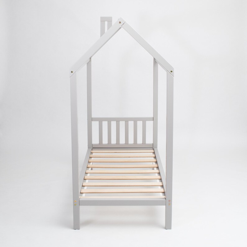 Direct head-on view of the light grey wooden house bed frame on legs showing precise symmetrical roofline and mattress slats.