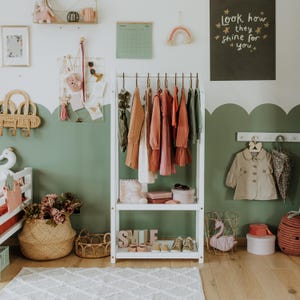 Self-serve child wardrobe station fitted with wooden coat hangers