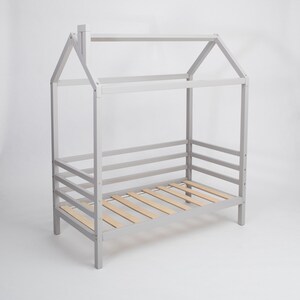Grey solid wood toddler house bed frame featuring removable safety rails displayed on a clean white backdrop.