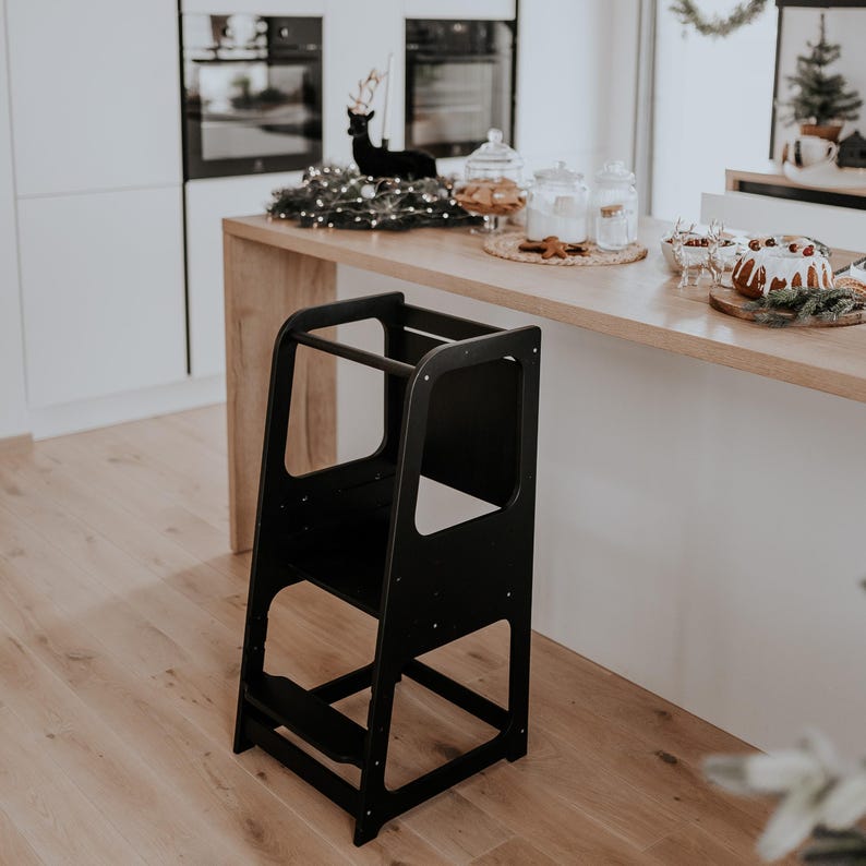 Black child standing tower with a blackboard panel, set near a light oak kitchen counter for modern apartments.