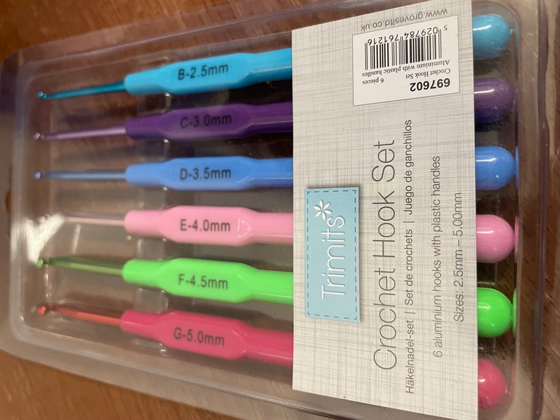 Pu&ograve; includere: Un set di sei uncinetti in una confezione di plastica trasparente. Gli uncinetti sono codificati a colori e etichettati con dimensioni da 2,5 mm a 5,0 mm. La confezione &egrave; etichettata "Crochet Hook Set" e "Trimits".