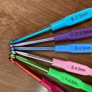 Pu&ograve; includere: Un set di sei ferri da uncinetto in vari colori, tra cui blu, viola, azzurro, verde, rosa e rosso. I ferri sono etichettati con le loro dimensioni in millimetri: B-2,5 mm, C-3,0 mm, D-3,5 mm, E-4,0 mm, F-4,5 mm.