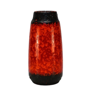 May include: A tall, ceramic vase with a speckled red and black glaze. The vase has a cylindrical shape with a slightly flared top and a dark black rim and base. The red glaze has a textured, dotted appearance.