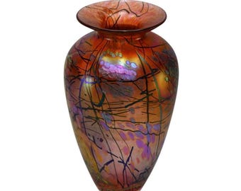 May include: A red glass vase with a wide mouth and a narrow base. The vase has a swirling pattern of black lines and iridescent purple and orange spots.