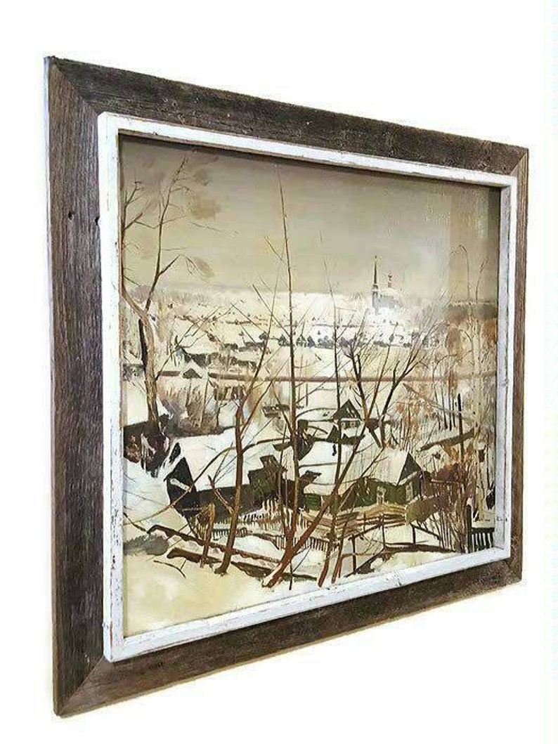 Pu&ograve; includere: Un dipinto di paesaggio invernale incorniciato con una cornice bianca e una cornice esterna in legno marrone. Il dipinto raffigura un villaggio innevato con case e alberi.