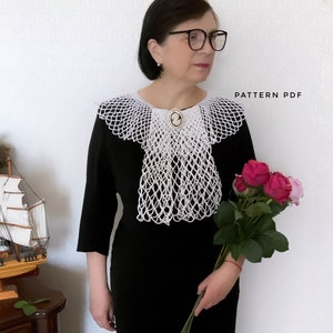 May include: A woman wearing a black dress with a white crocheted collar. The collar has a delicate, lacy design and is adorned with a cameo brooch. She is holding a bouquet of pink roses.
