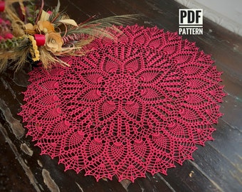 May include: A bright pink crochet doily with a delicate, intricate pattern. The doily is circular and has a scalloped edge. PDF PATTERN is written in the top right corner of the image.