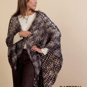 Peut inclure: Une femme porte un châle fait à la main, à tissage ouvert, dans des tons de gris, de noir et d'argent. Le châle a un design texturé et ouvert avec un effet scintillant. L'image comprend le texte "PATTERN - PDF".