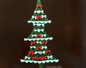 May include: A green crocheted Christmas tree with white lace trim and red and white bows. The tree is on a brown background. PATTERN PDF.