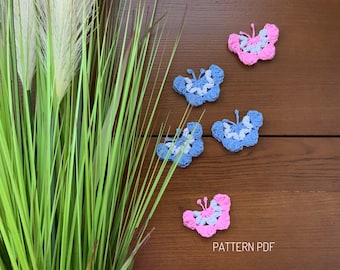 May include: Four crocheted butterflies, two blue and two pink, on a wooden surface with a green plant in the background. The text "PATTERN PDF" is visible at the bottom of the image.