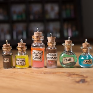 May include: Six small glass bottles with cork stoppers and handwritten labels. The labels read "Lies", "Common Sense", "Solution for Brexit", "Antidote to Government", "Truth", and "Logic".