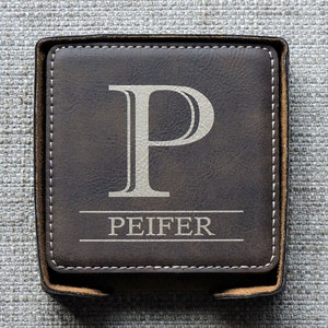 May include: Brown leather coaster with a white monogram "P" and the name "PEIFER" in white lettering.