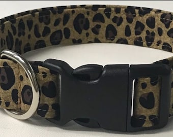 May include: A brown and black leopard print dog collar with a black plastic buckle and a silver metal D-ring.