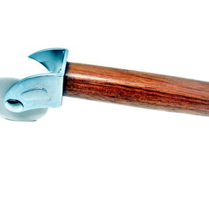 May include: A pizza cutter with a wooden handle and a silver metal blade. The handle is a dark brown color, and the blade is a rounded, gray wheel. The cutter is designed for slicing pizza.