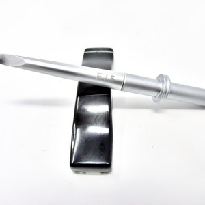May include: A silver crochet hook with a black and white handle. The hook is labeled "F/5".