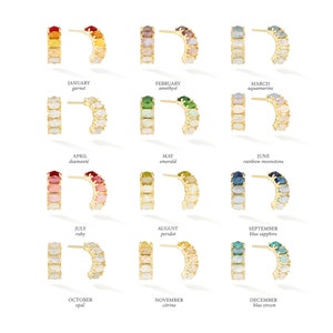 May include: Twelve pairs of gold hoop earrings with a semi-circle of gemstones. Each pair represents a different month of the year and features a different birthstone. The earrings are arranged in rows of three, with the months listed below each row.