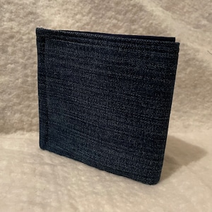 Könnte beinhalten: Eine dunkelblaue Jeansbörse mit strukturierter Oberfläche.