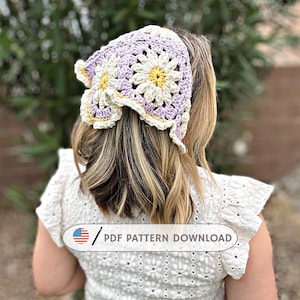 May include: A crocheted headband featuring a daisy design in shades of lavender, cream, and yellow. The headband is worn on a person's head, with the back of the person facing the camera. The text "PDF PATTERN DOWNLOAD" is visible on the image.