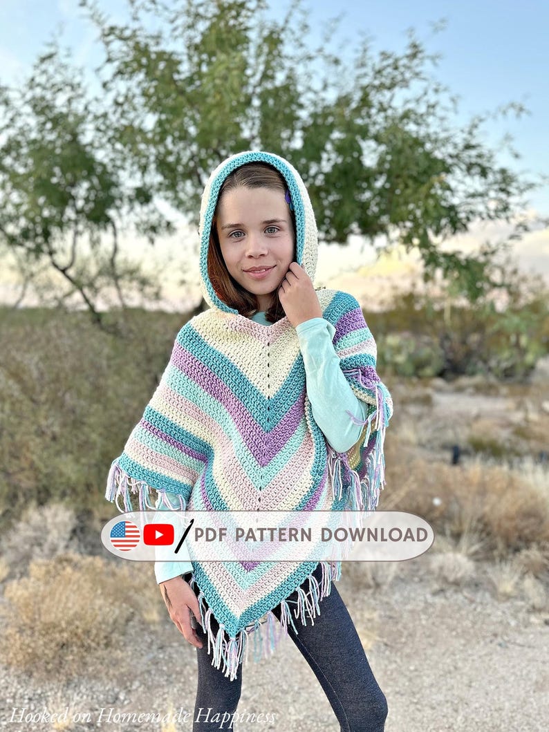 May include: A colorful crochet poncho with a hood, featuring stripes of cream, blue, purple, and pink. The poncho has a V-neck design and fringe along the bottom. The image includes the text "PDF PATTERN DOWNLOAD".