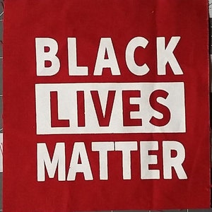 以下が含まれることがあります： 白い文字で「BLACK LIVES MATTER」と印刷された赤い布の正方形です。