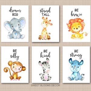 May include: Set of six watercolor prints featuring adorable animal illustrations with inspirational messages. The prints include an elephant with "dream big", a giraffe with "stand tall", a lion with "be brave", a monkey with "be silly", a zebra with "be kind", and a rhinoceros with "be strong".
