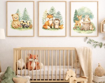 May include: Three framed watercolor prints featuring woodland animals: a bear, fox, deer, hedgehog, and owl. The prints have a light wood frame and are displayed above a wooden crib. The artwork has a soft color palette with green, brown, and orange tones.