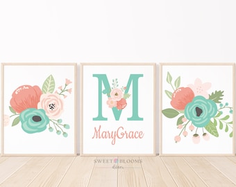 May include: Three printable wall art prints featuring a floral design with pink, peach, and teal flowers. The middle print has a large teal letter M and the text "Mary Grace" below it.