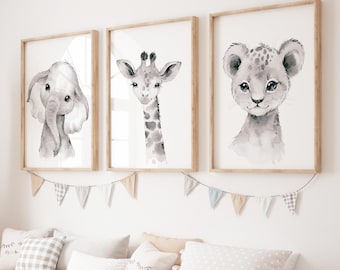 May include: Three framed watercolor prints of baby animals: an elephant, a giraffe, and a lion cub. The prints are in neutral tones and are displayed above a bench with pillows. A garland of small flags hangs below the prints.
