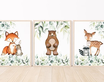 May include: Three framed watercolor illustrations of woodland animals. The first features a fox and a rabbit, the second a bear, and the third a deer and a raccoon. All three illustrations have a green leafy background.